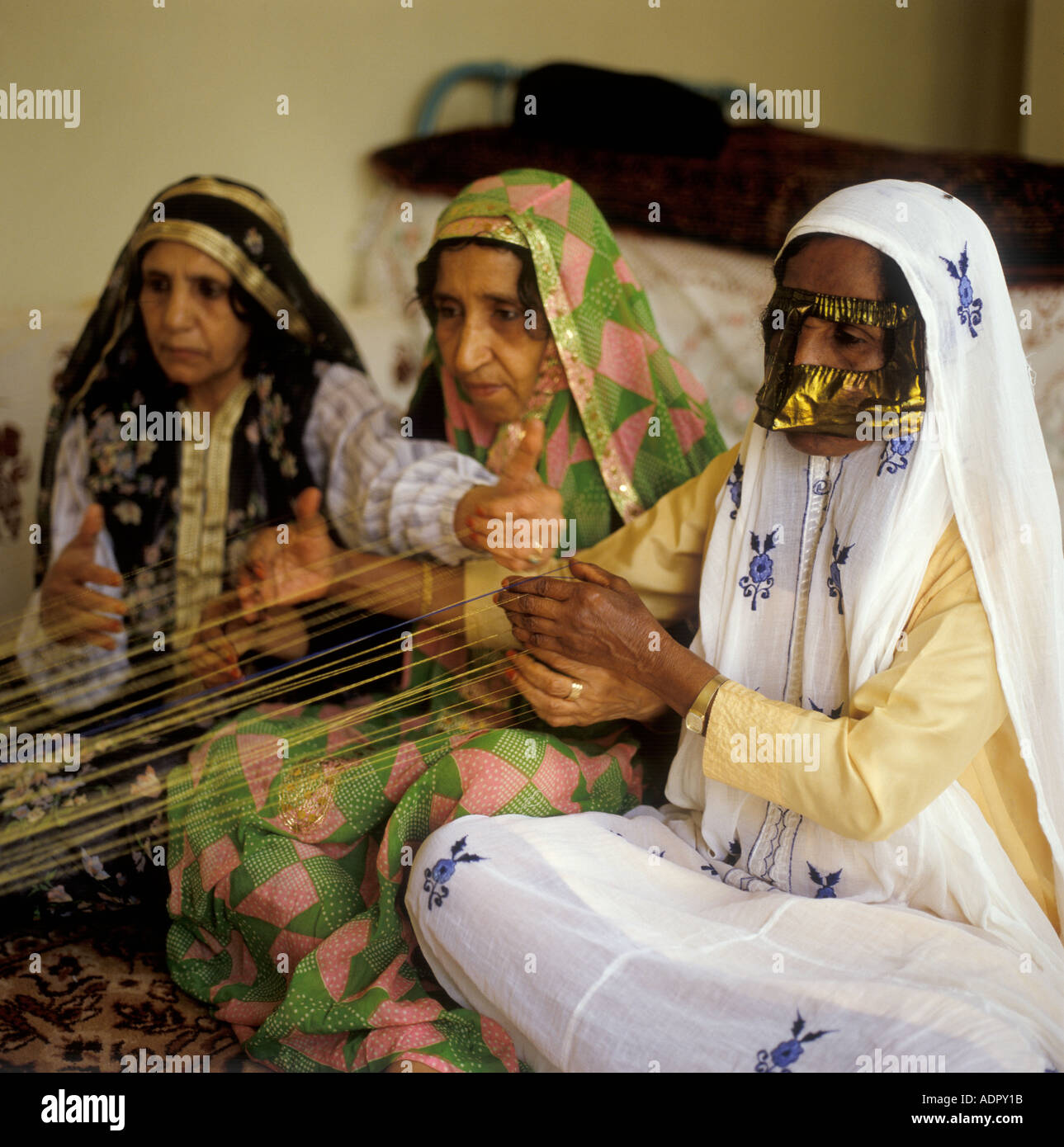 Ladies weaving gold braid Bahrain Stock Photo Alamy