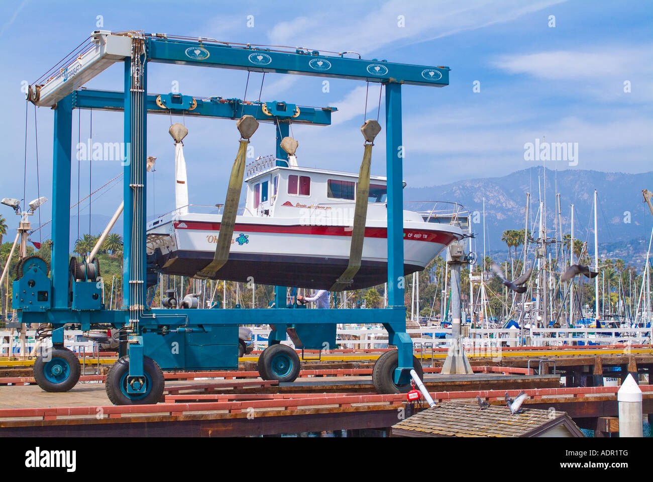 Yacht in dry dock being lifted by automated crane Stock Photo