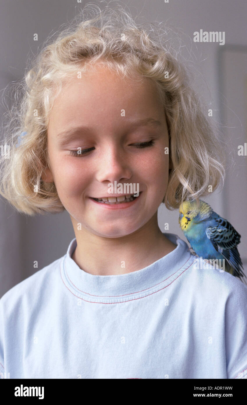 Girl with a parakeet sitting on her shoulder Stock Photo
