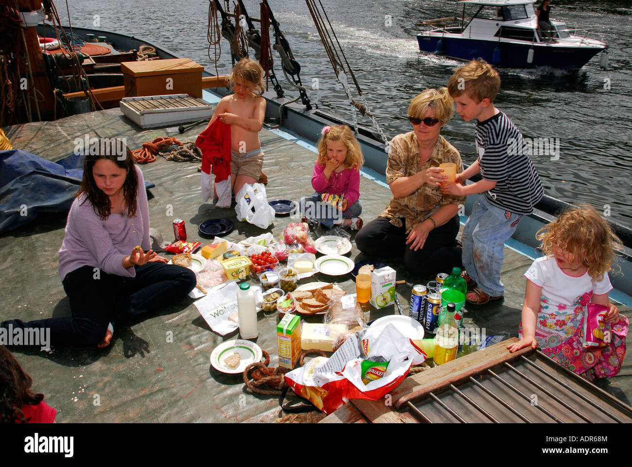 People having a picnic onboard The Henry, an old Thames boat during