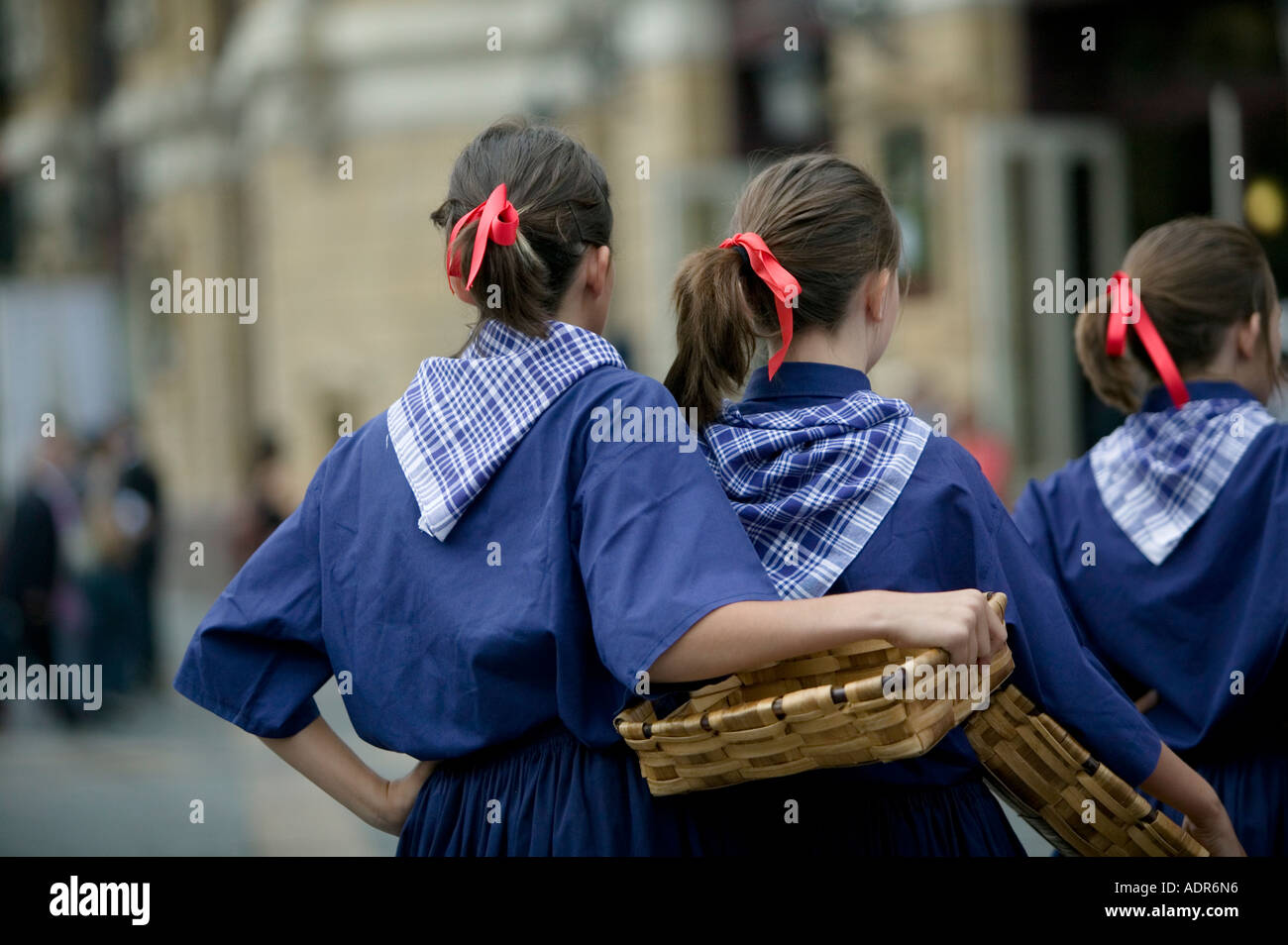 Basque girls dressed in blue and carrying wicker baskets perform a ...