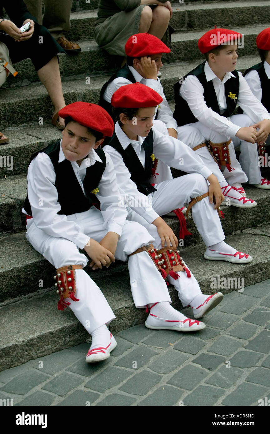 Young Basque boys sitting on steps after performing traditional folk ...