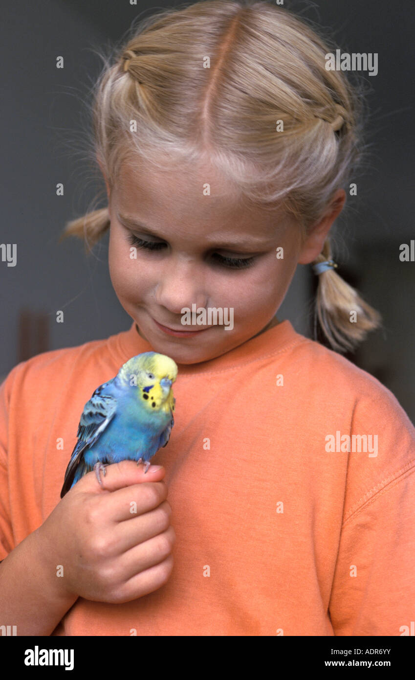 Girl with a parakeet sitting on her hand Stock Photo