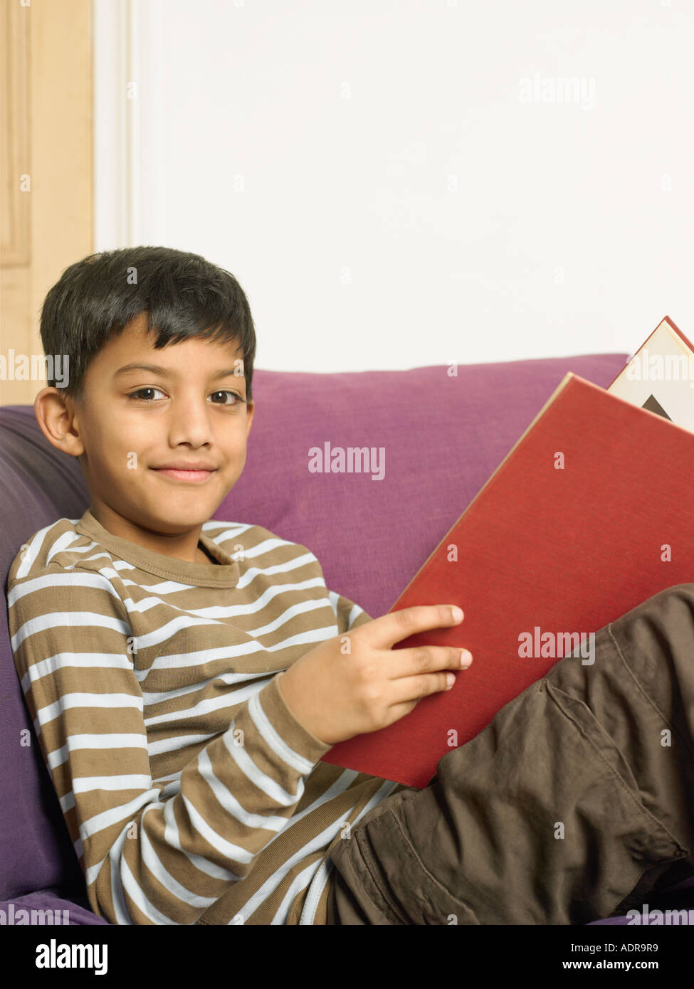Boy Reading A Book On Sofa Stock Photo Alamy