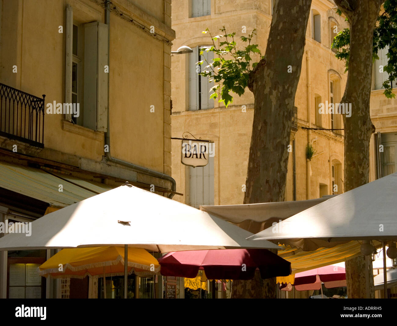 a french bar sign hangs above an outdoor cafe with parasols in montpellier  france, languedoc Stock Photo - Alamy