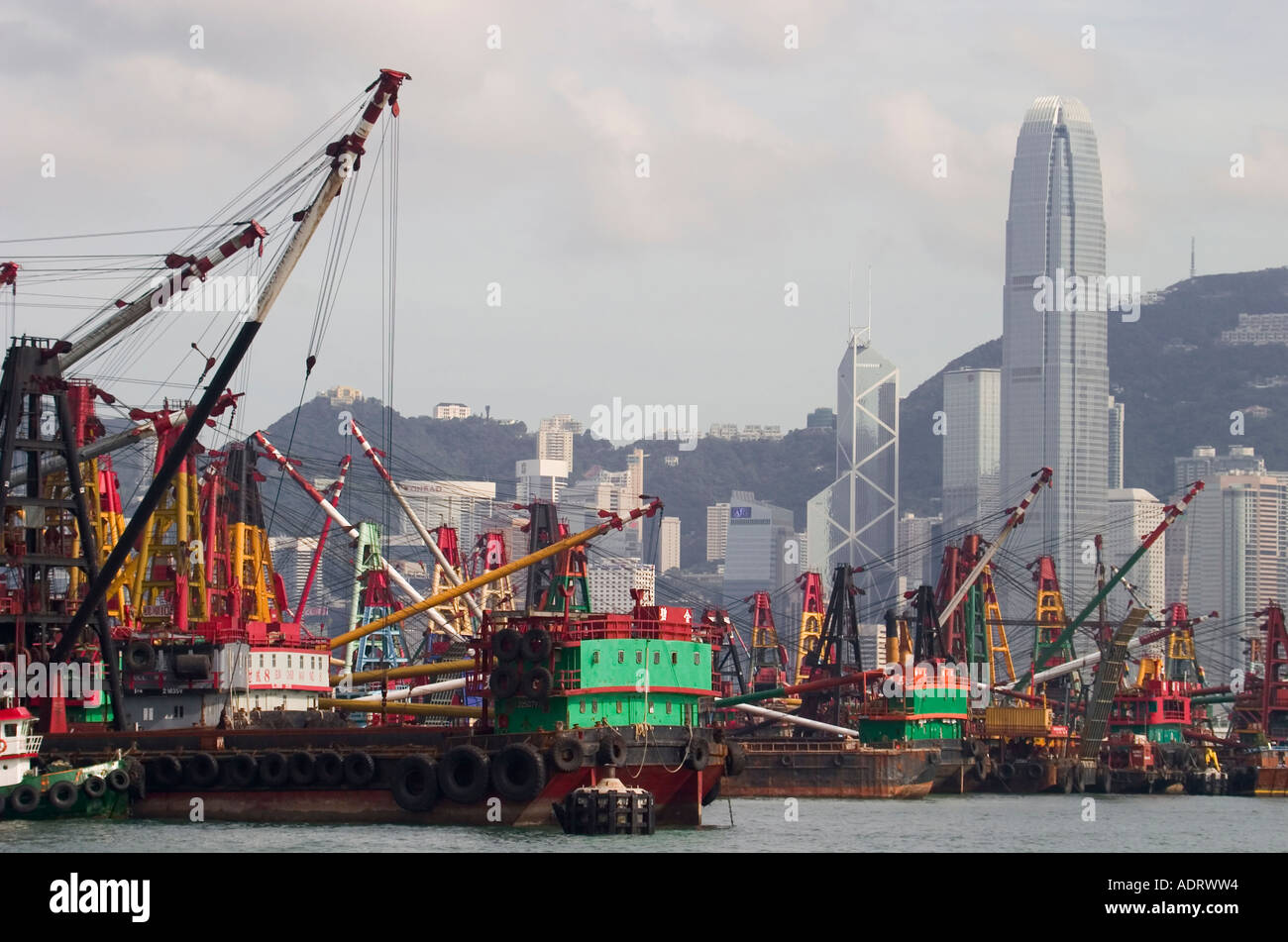 Hong Kong Skyline on clear day with  shipping container transfer barge cranes in foreground asia asian Stock Photo