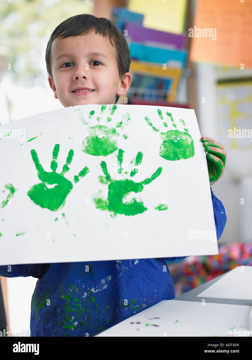 Boy presenting his finger painting in art class Stock Photo Alamy