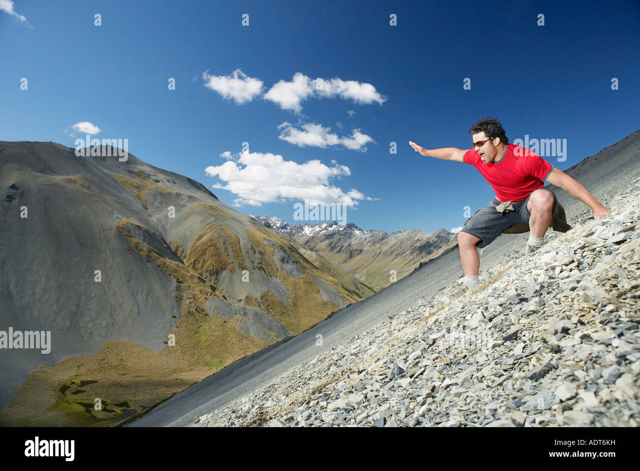 Man sliding down screen field in mountains Stock Photo - Alamy