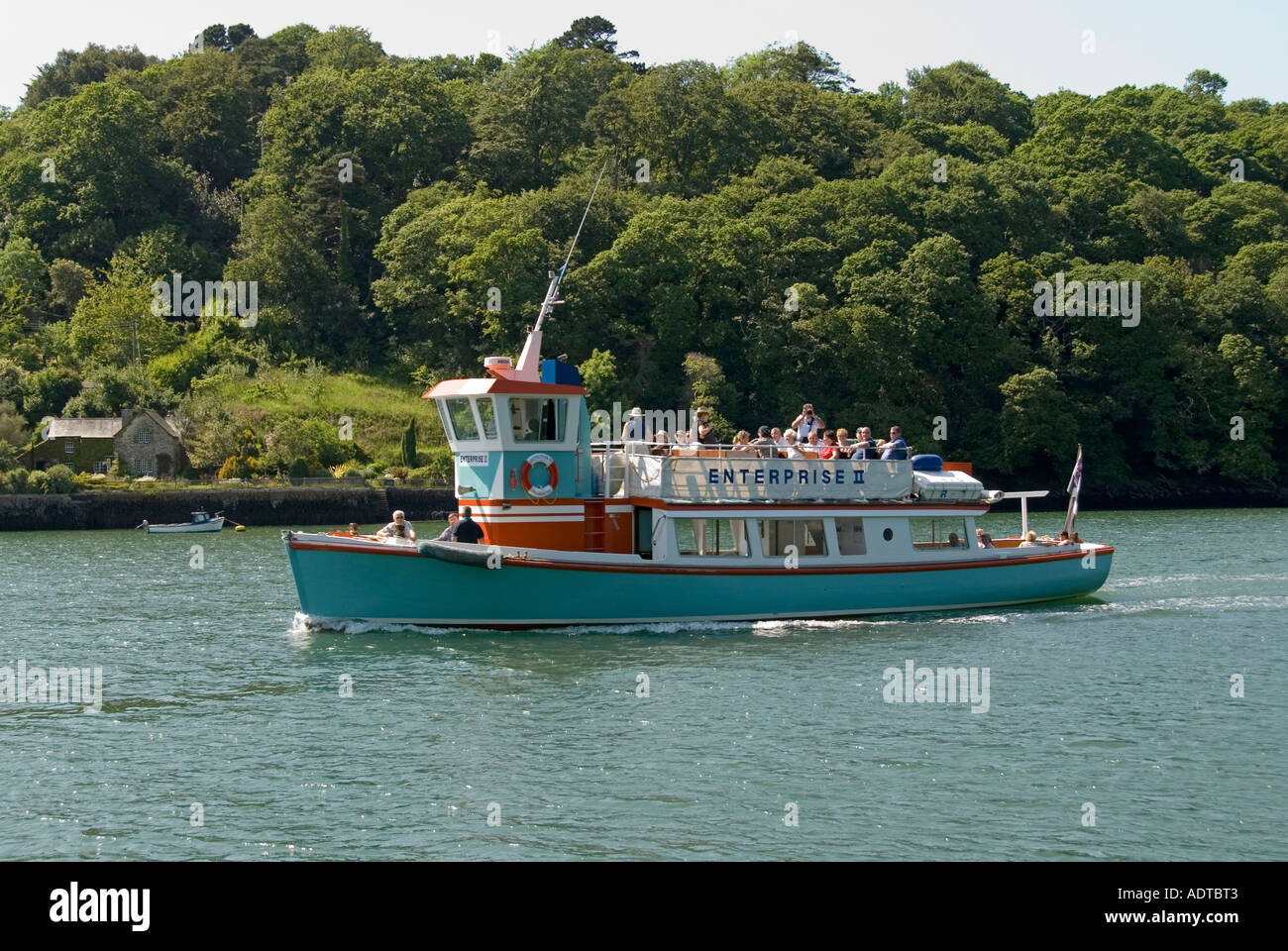 Trelissick river tour boat with passengers on Carrick Roads with woodland beyond Stock Photo