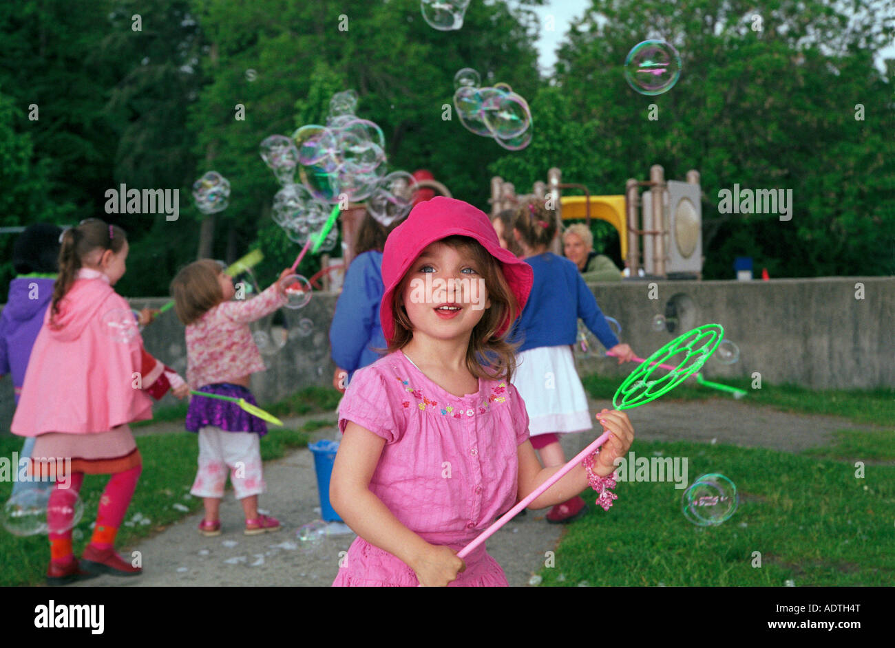 A group of young girls blowing big bubbles in a park Stock Photo Alamy