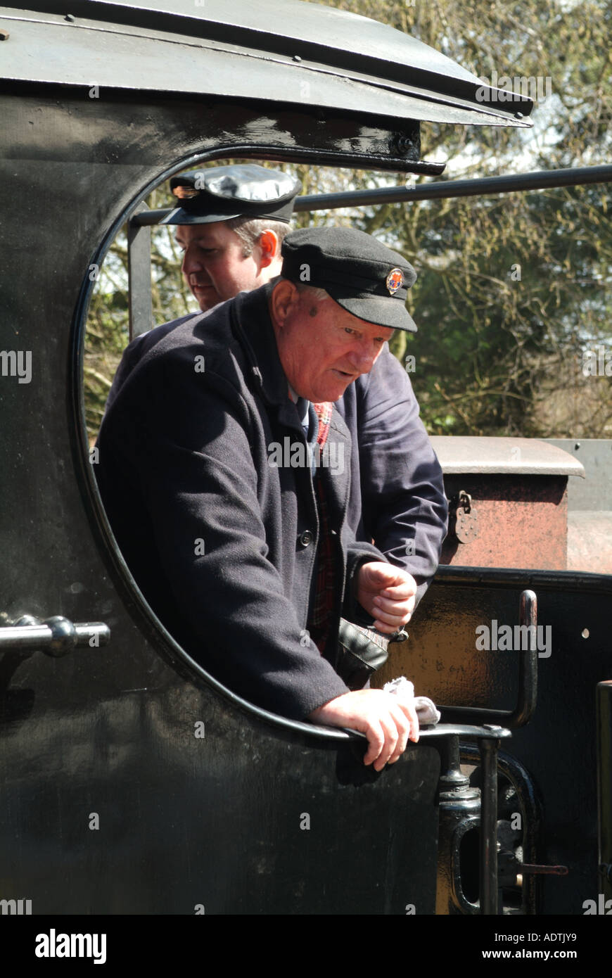 Driver and fireman standing on the footplate at Holt Station on the North Norfolk Railway, Norfolk, England, UK (editorial only) Stock Photo