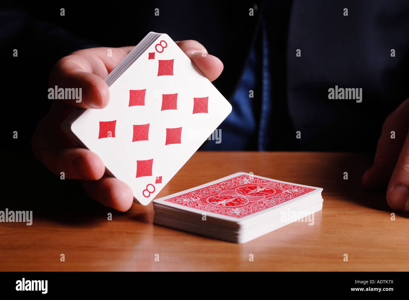 Man cutting deck of cards to eight of diamonds Stock Photo Alamy