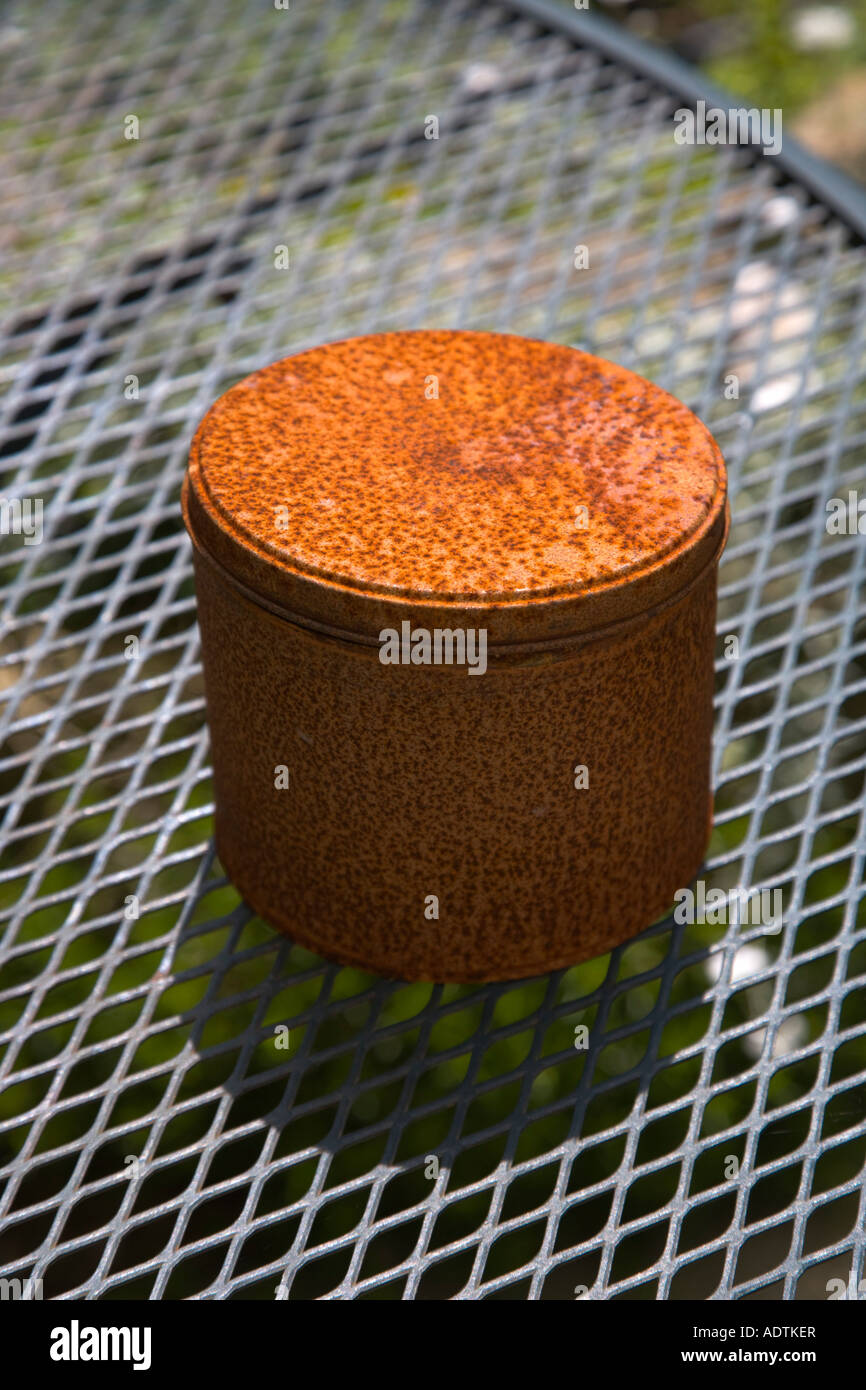 Rusty tin containing a citronella candle to ward off flying insects