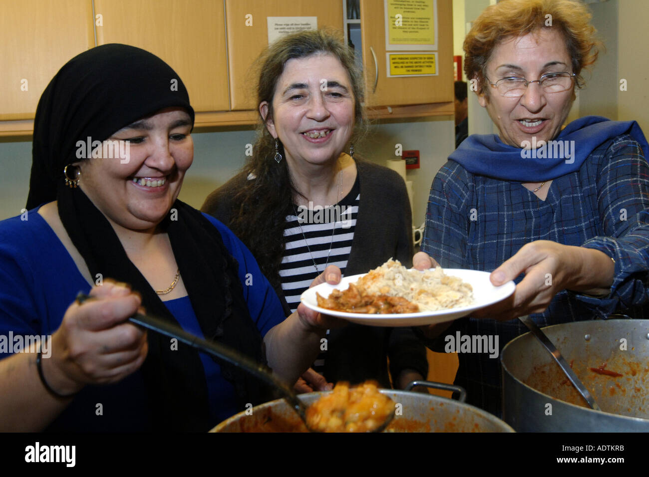 Volunteers serve curry for refugees and asylum seekers in a soup kitchen at a church hall Bradford West Yorkshire Stock Photo