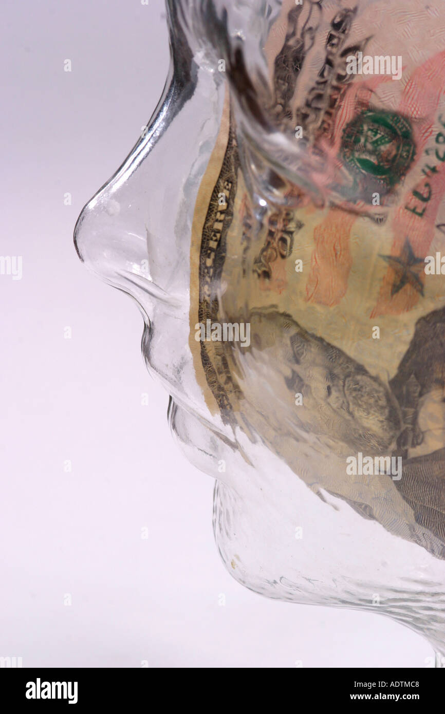 Dollar notes inside glass head profile view Stock Photo