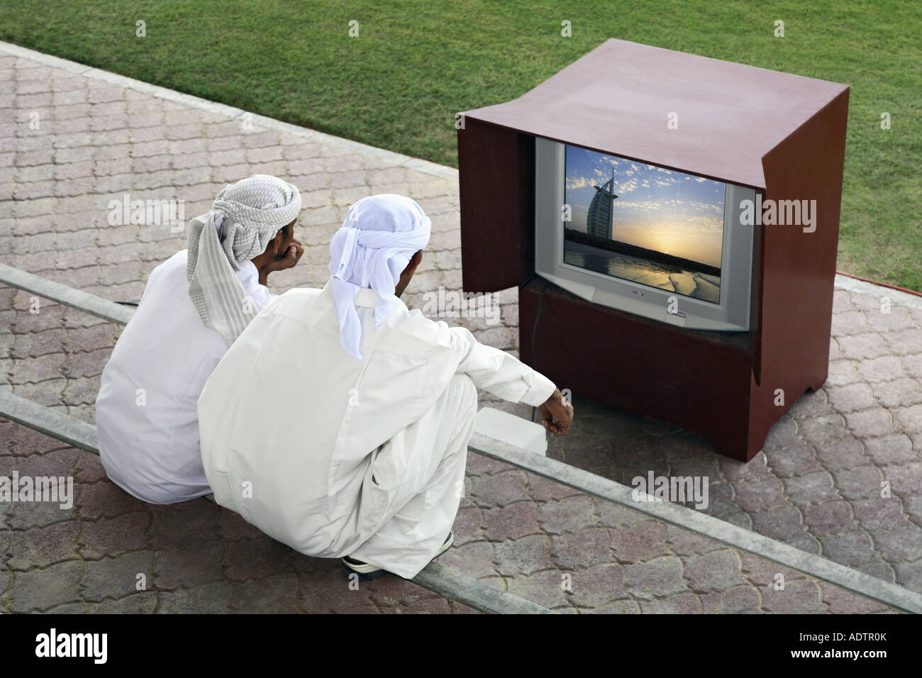 two arab men watching TV, Dubai (picture on TV is mine Stock Photo Alamy