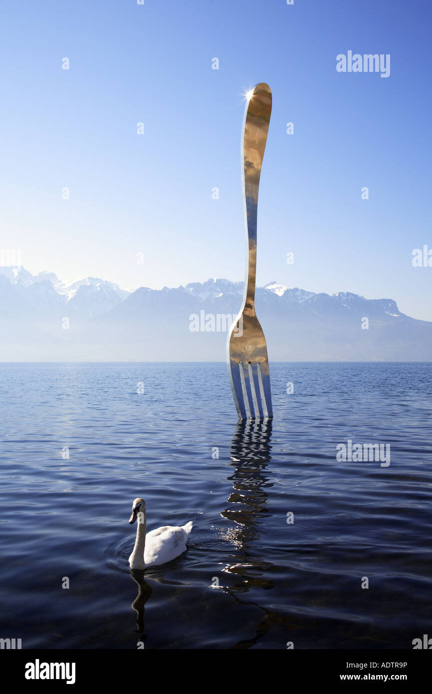 sculpture of a giant fork stuck in water - Switzerland Stock Photo