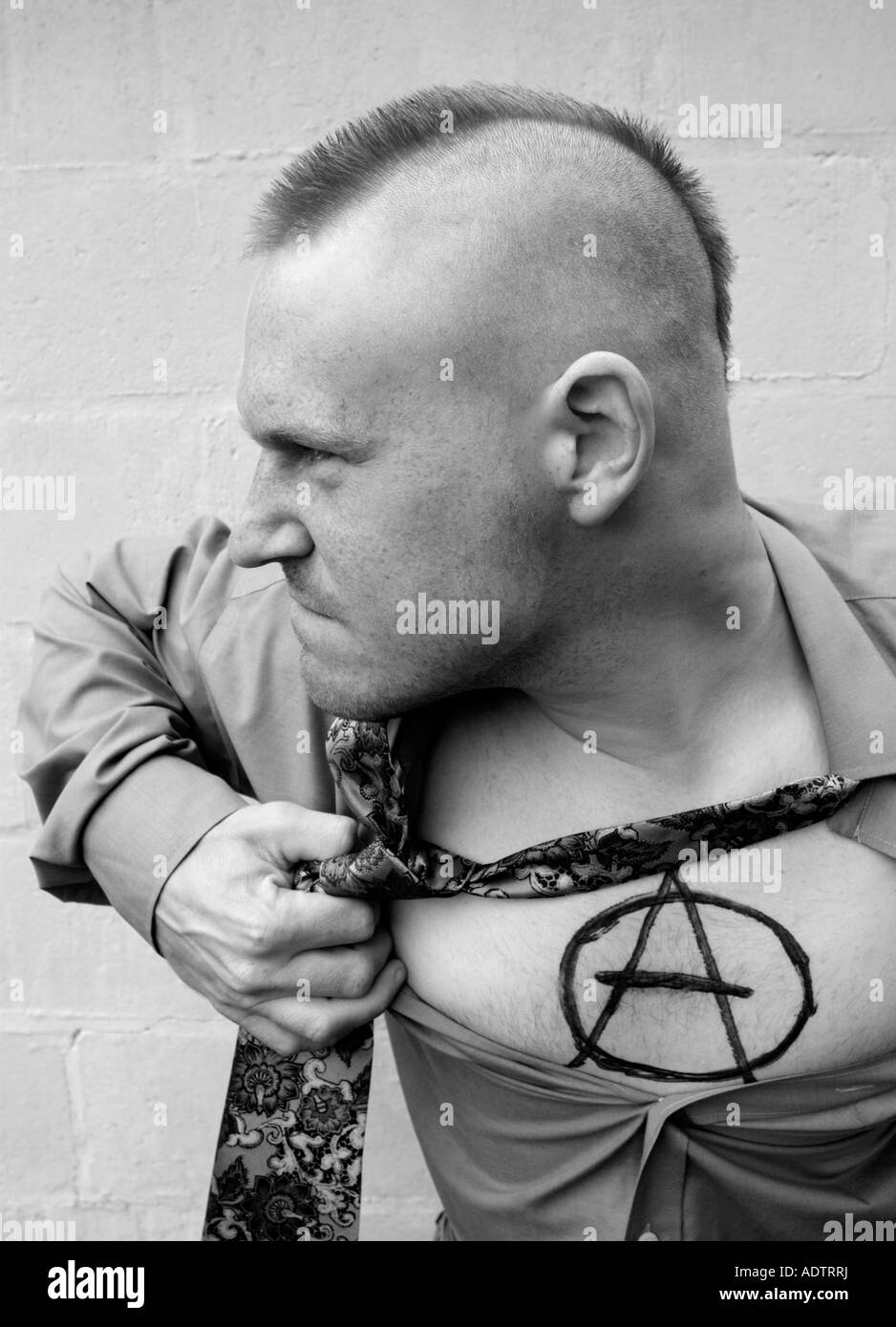 Anarchy Punk. Man ripping his shirt to reveal the Anarchy sign. Stock Photo