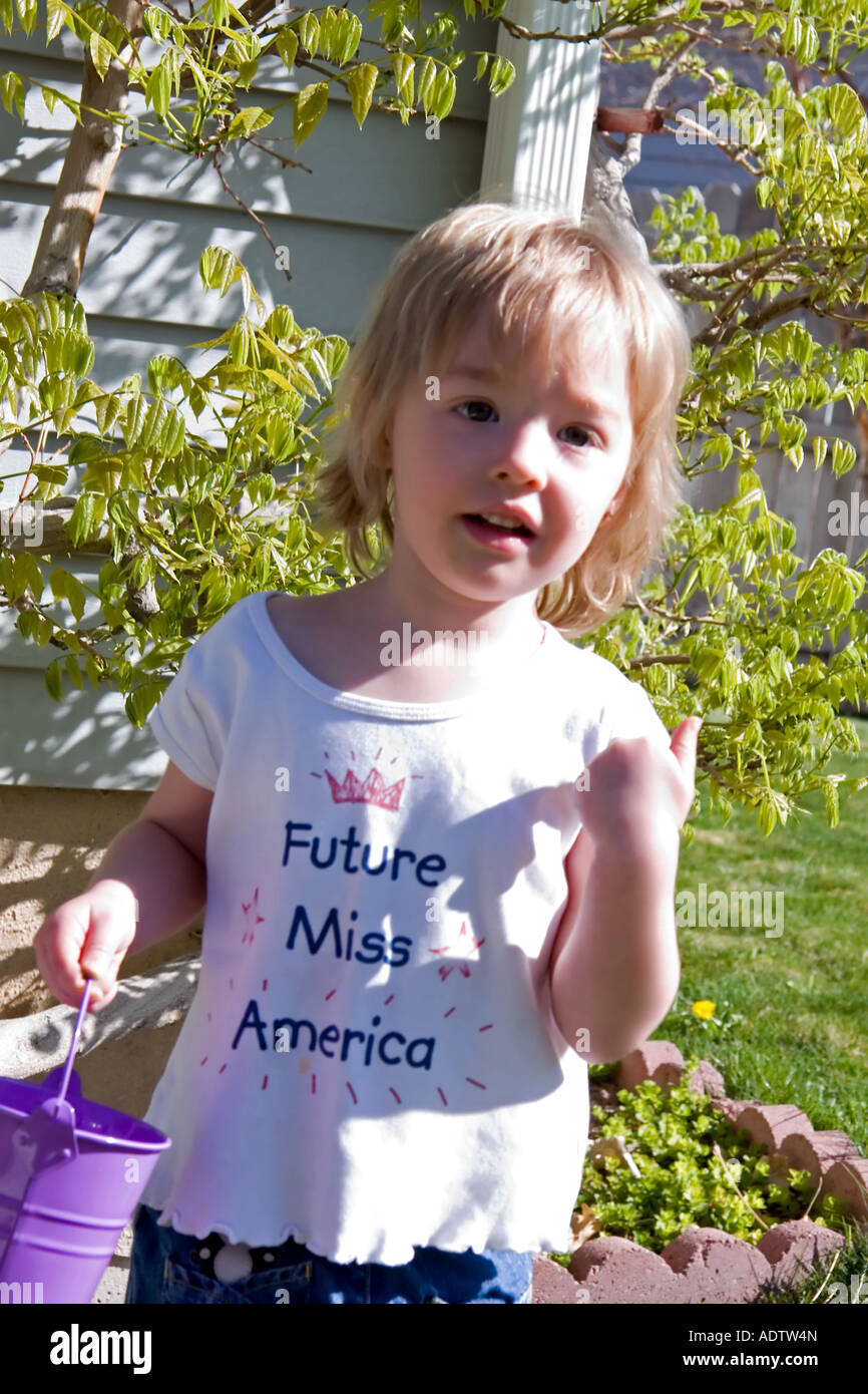 A 3 year old girl is happily searching for more Easter eggs in a backyard hunt in Utah, USA