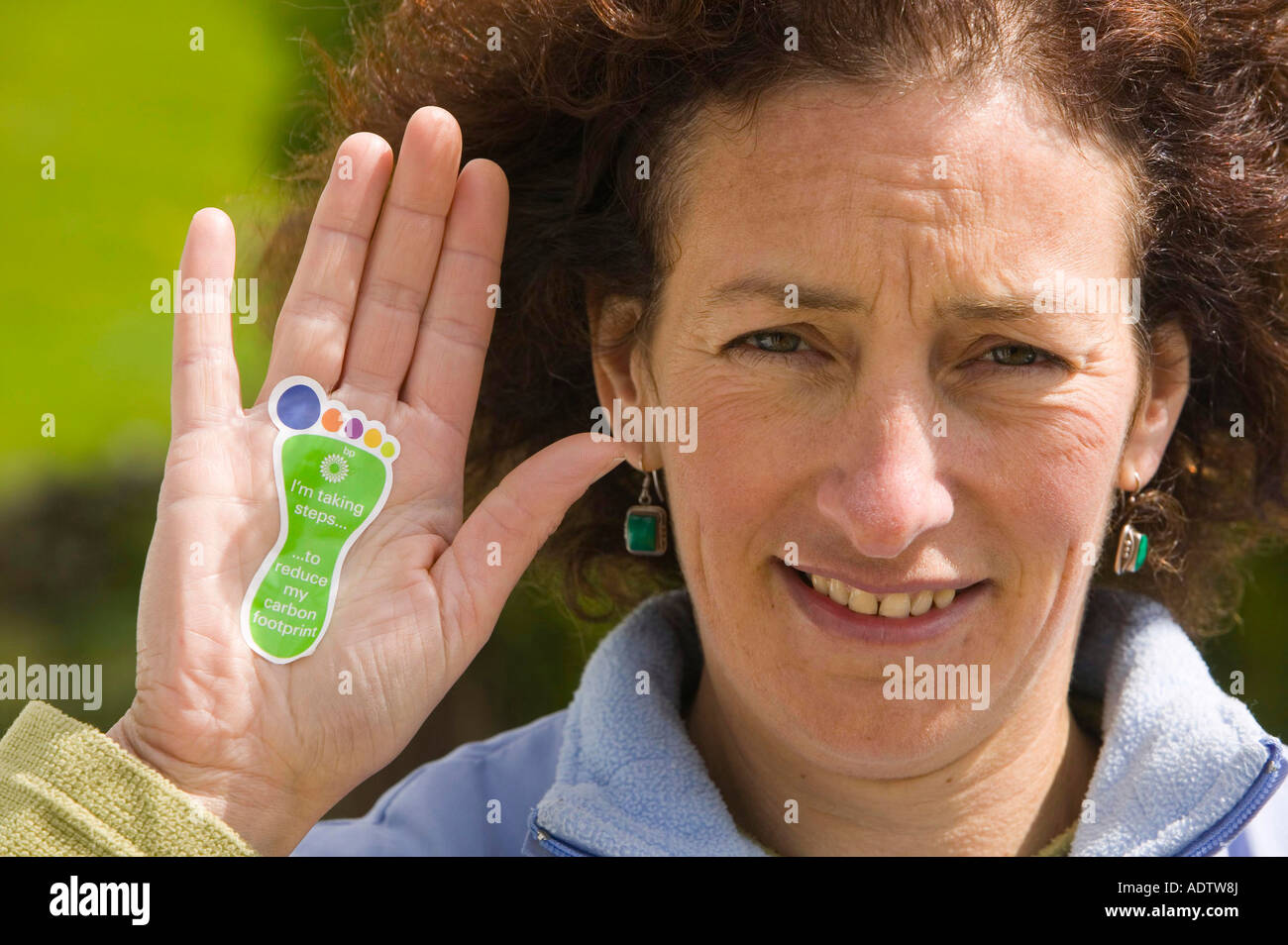 A woman with a sticker about reducing your carbon footprint Stock Photo