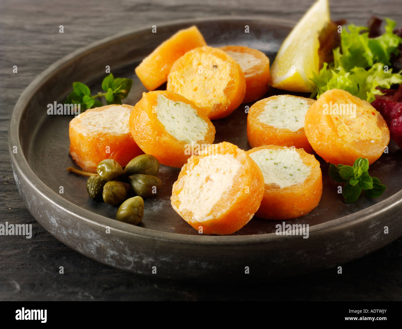 Smoked salmon rolls filled with cream cheese and cream cheese and peppers in a party buffet setting Stock Photo