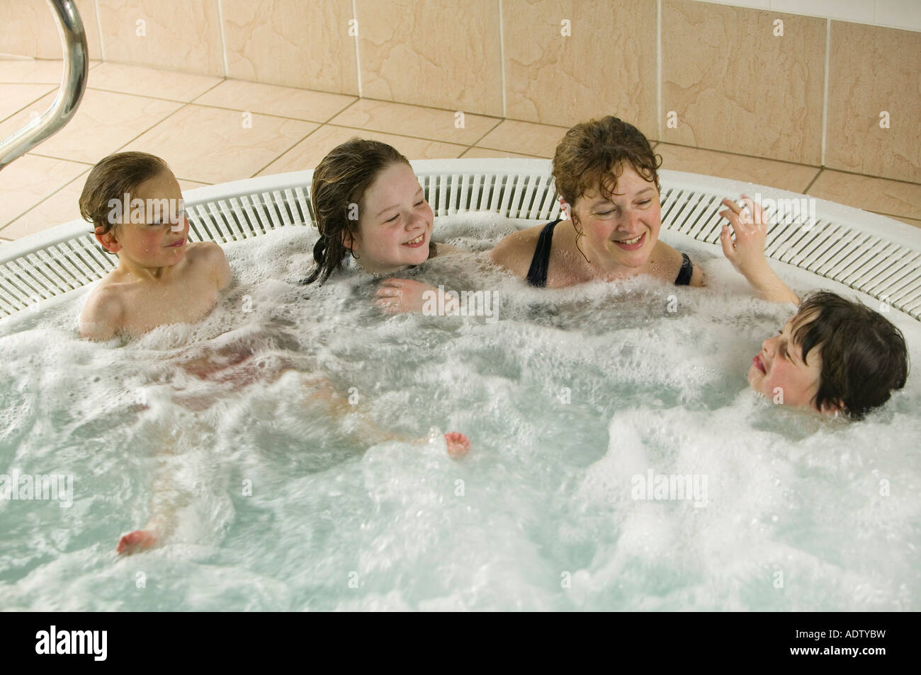 A family in a Jacuzzi water spa bath, UK Stock Photo Alamy