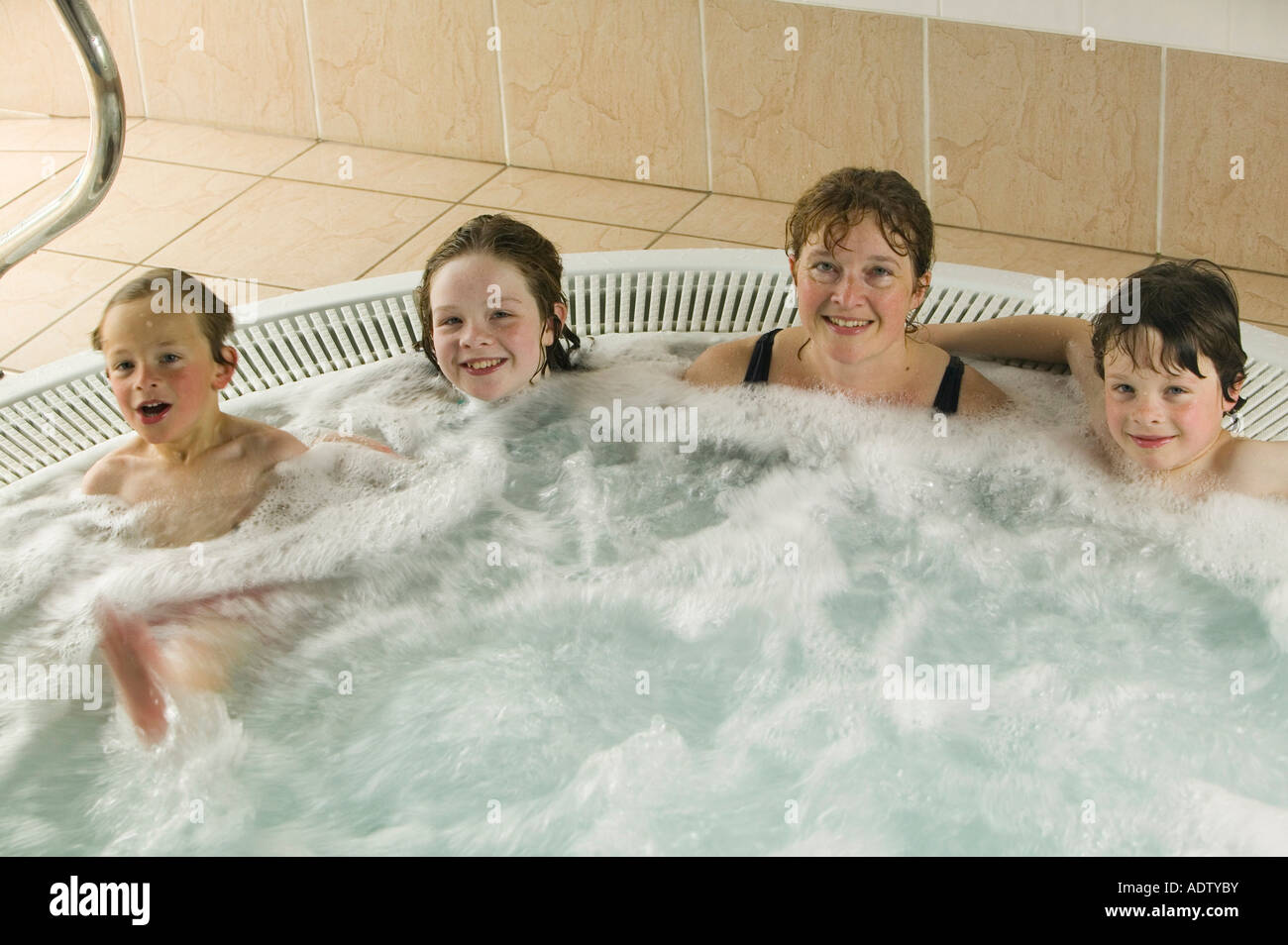 A family in a Jacuzzi water spa bath, UK Stock Photo Alamy