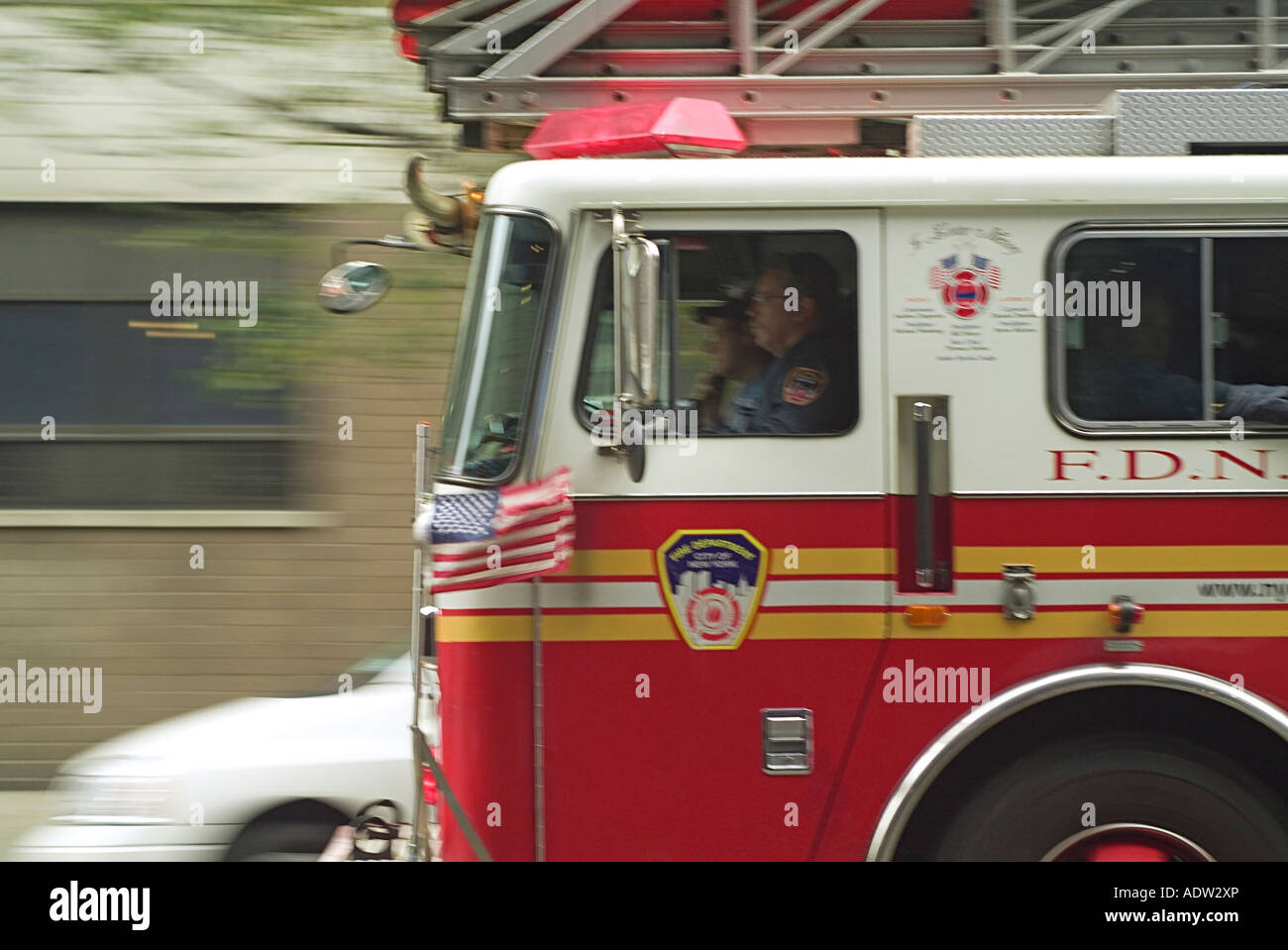 Red fire truck and fire fighters of FDNY - Fire Department of NY - racing in traffic with high speed - background blurry Stock Photo