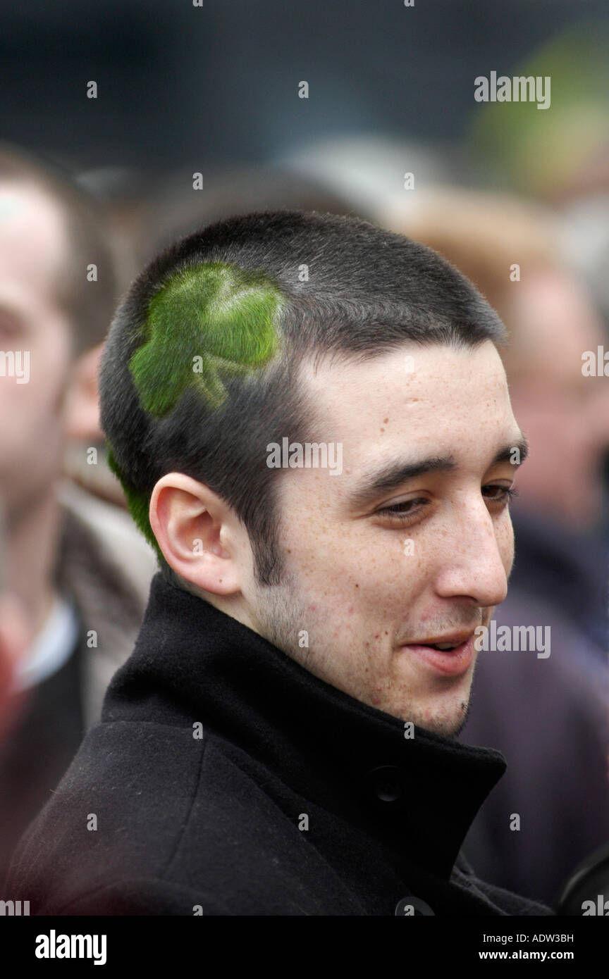 Irish man at Cheltenham Gold Cup horse Race with a picture of a four leaf clover on the side of his head Stock Photo