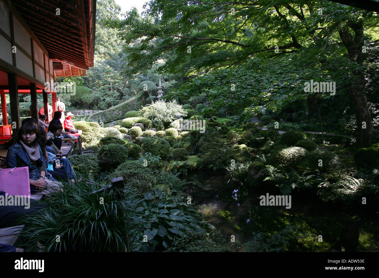 Japanese people sit on the old wooden floor of Sanzen In temple looking