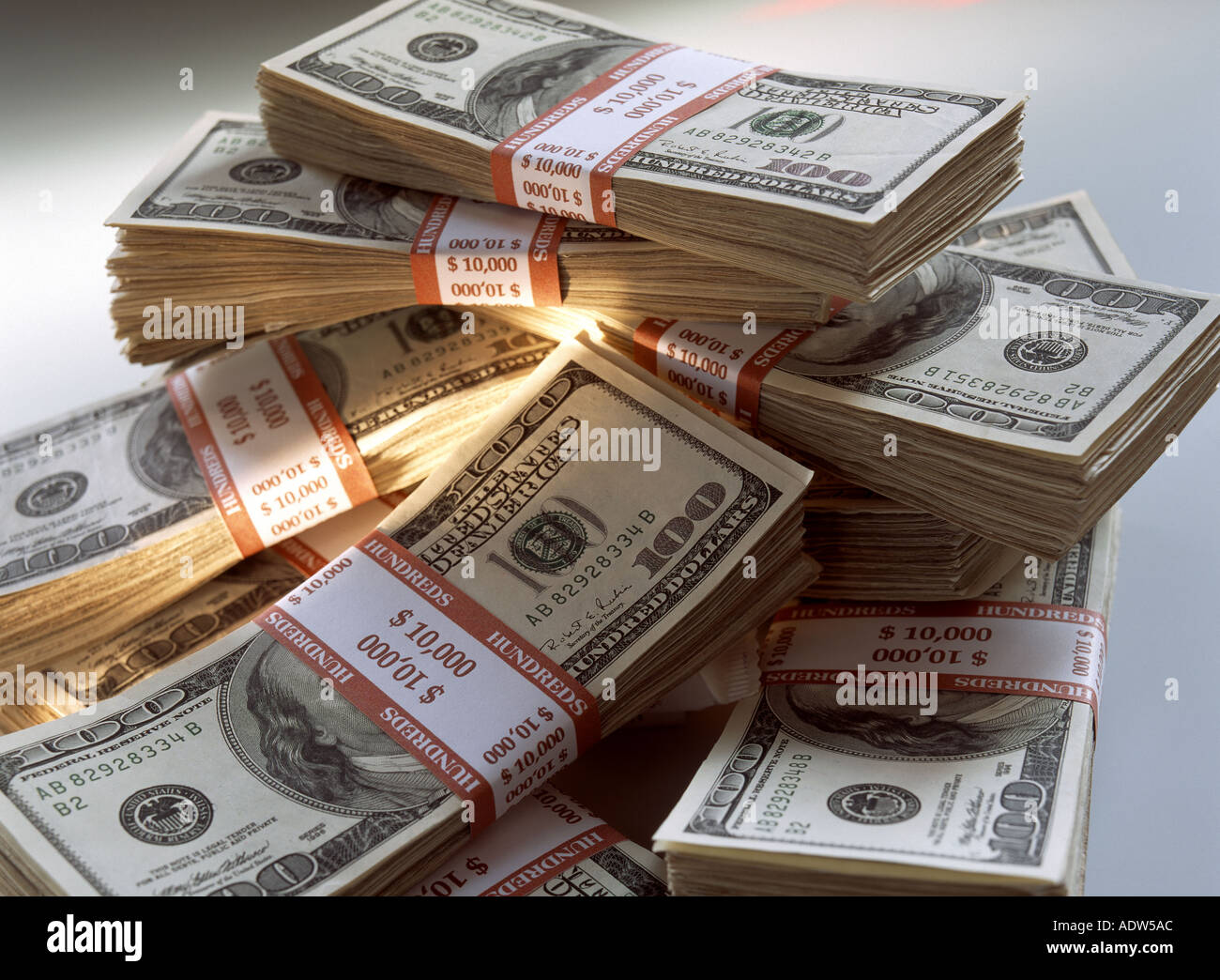 WADS OF 100 US DOLLARS BANKNOTES WITH GOLDEN BEAM Stock Photo