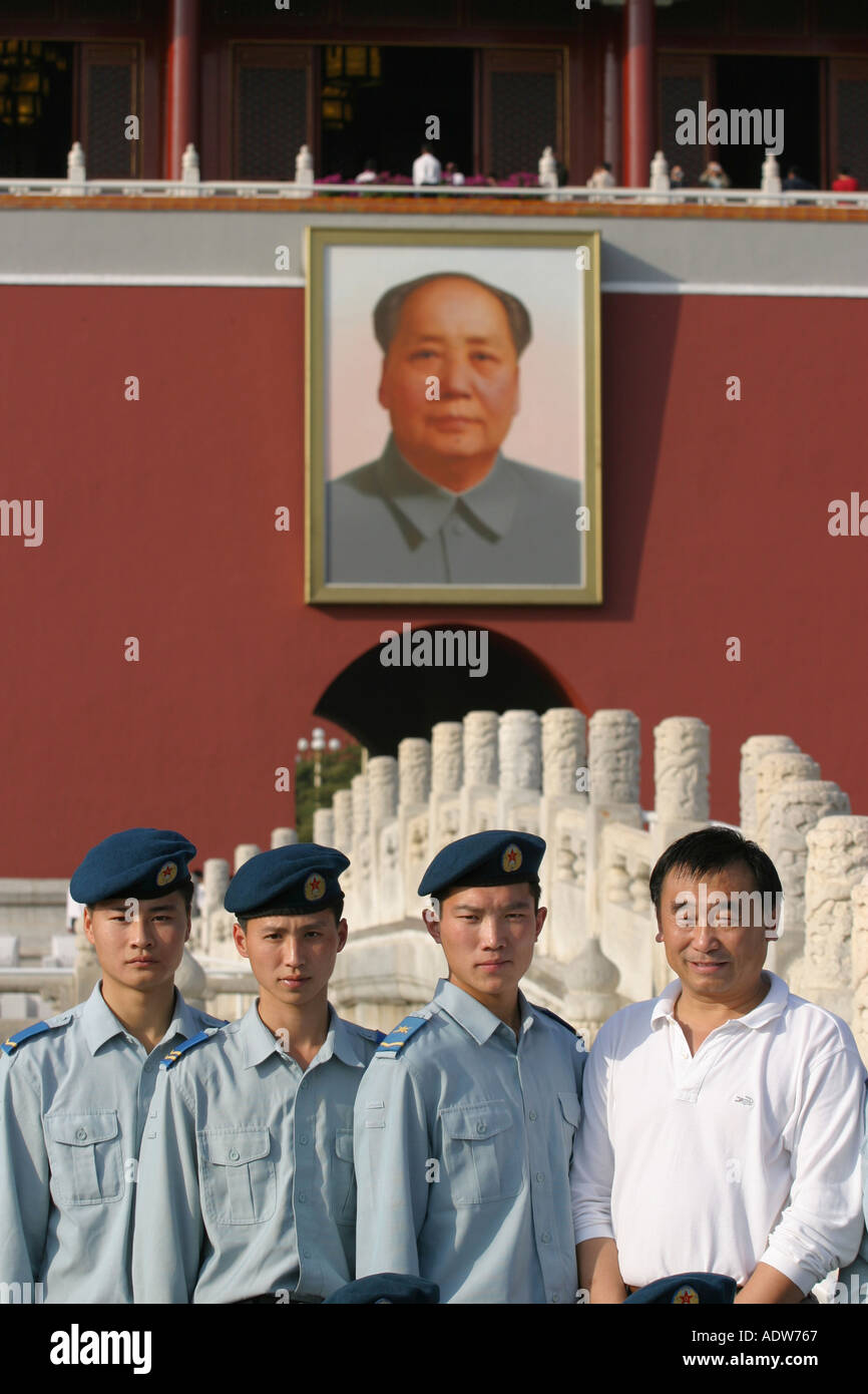Young Chinese men in military uniforms pose for a photo infront of the Mao portrait on the Gate of Heavenly Peace Tiananmen Stock Photo