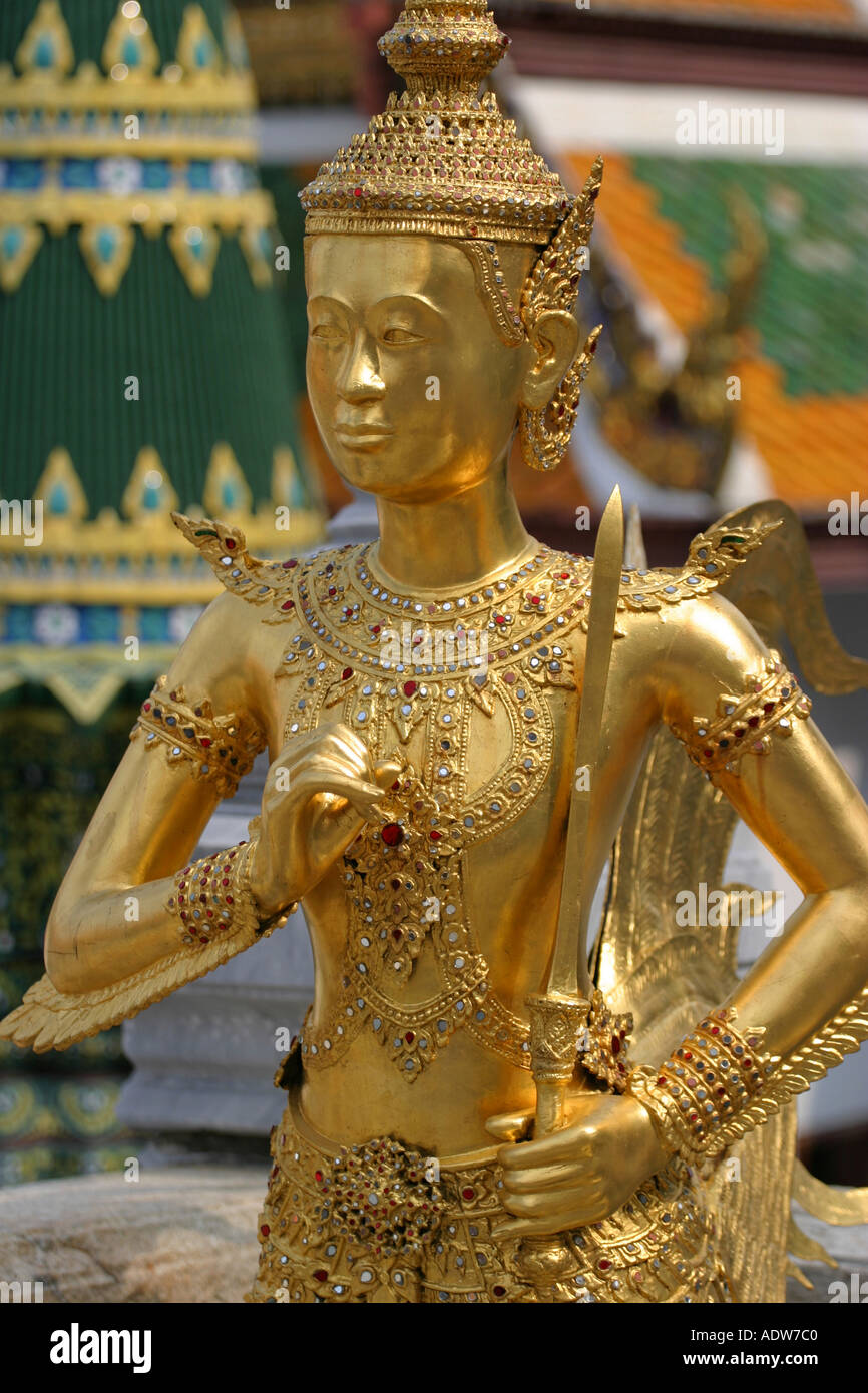 Golden guardian statue stands in front of the colourful Grand Palace ...