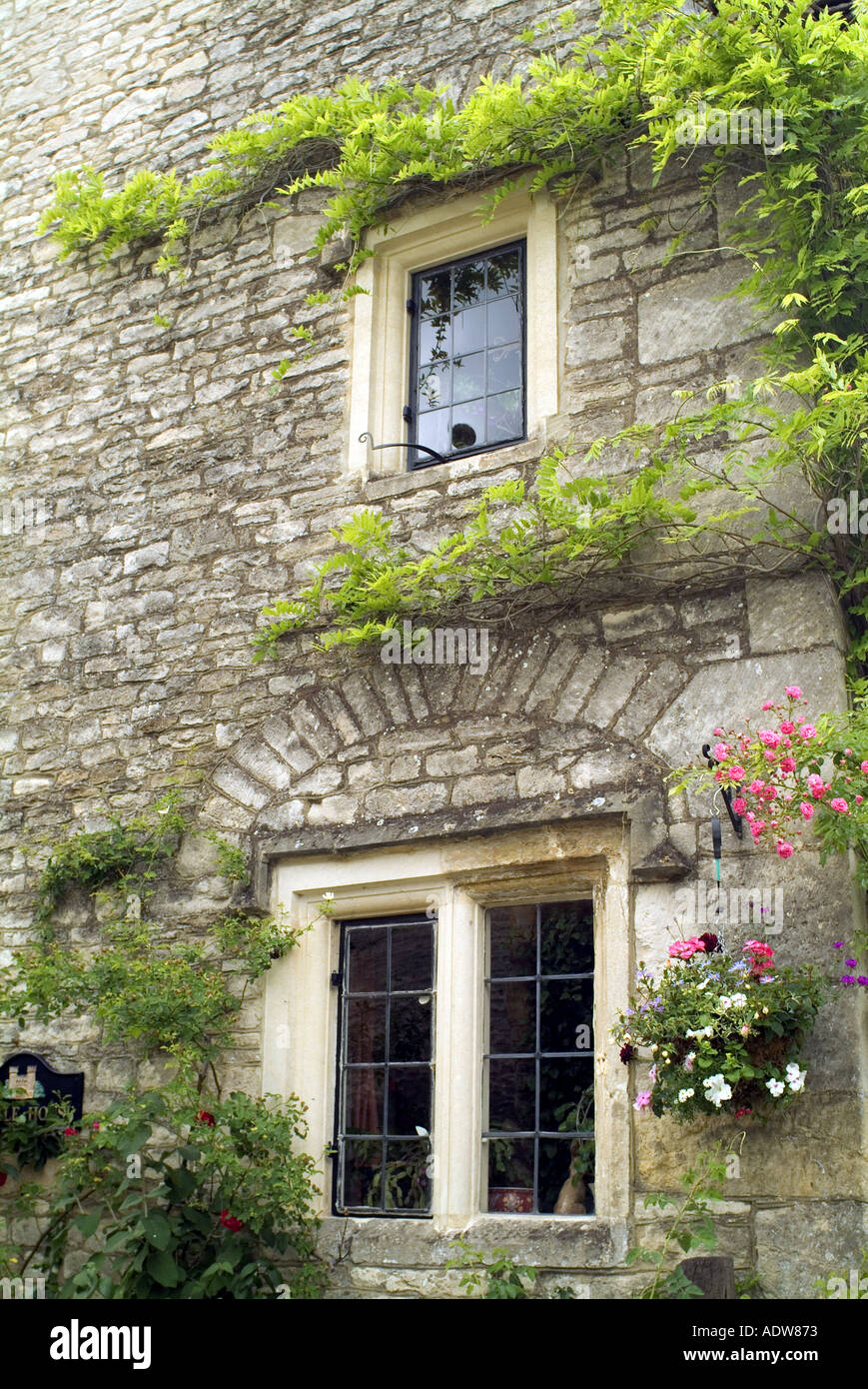 UK England Cotswolds Wiltshire Castle Coombe stone cottage with stone mullion leaded windows JMH0422 Stock Photo