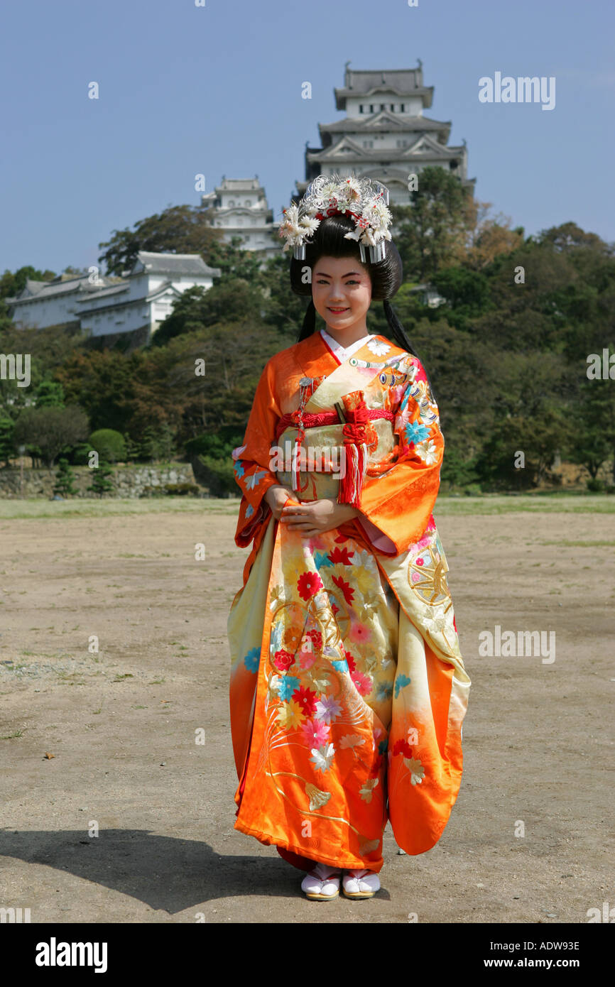 Young Japanese woman wearing a bright orange traditional Kimono poses  infront of Himeji castle Kansai Japan Asia Stock Photo - Alamy