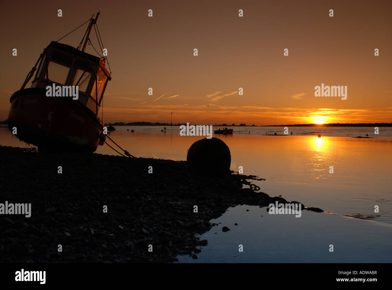 Fishing boat at sunset Stock Photo - Alamy
