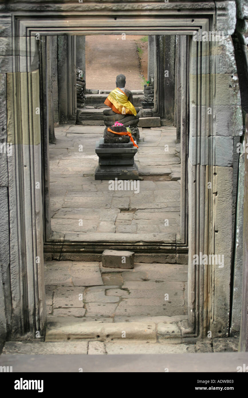 An ancient stone buddhist altar with burning incense sits in a corridor at the Bayon temple