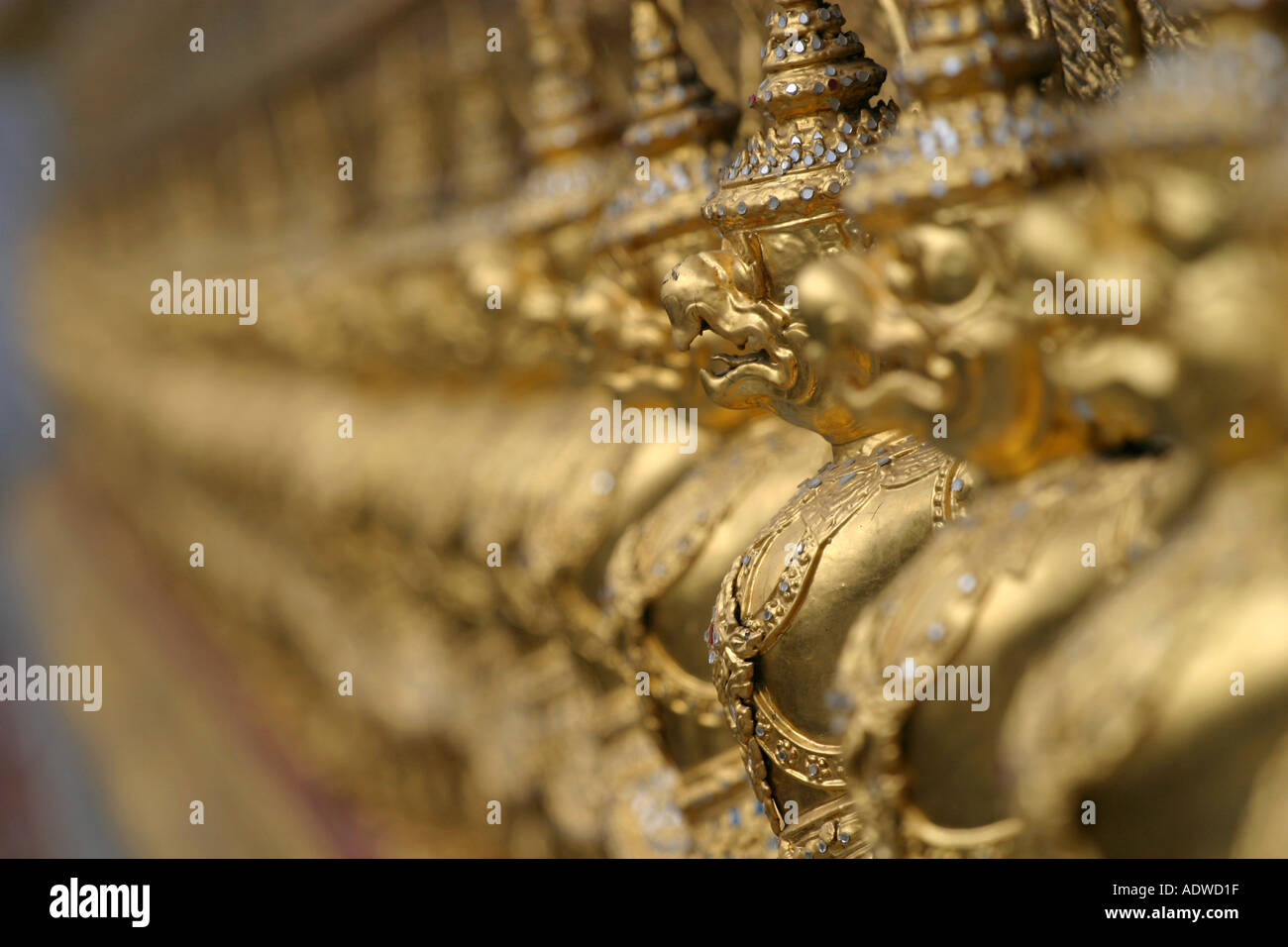 Golden guardian angel statues stand in a long row with shallow depth of field Grand Palace Bangkok Thailand Asia Stock Photo