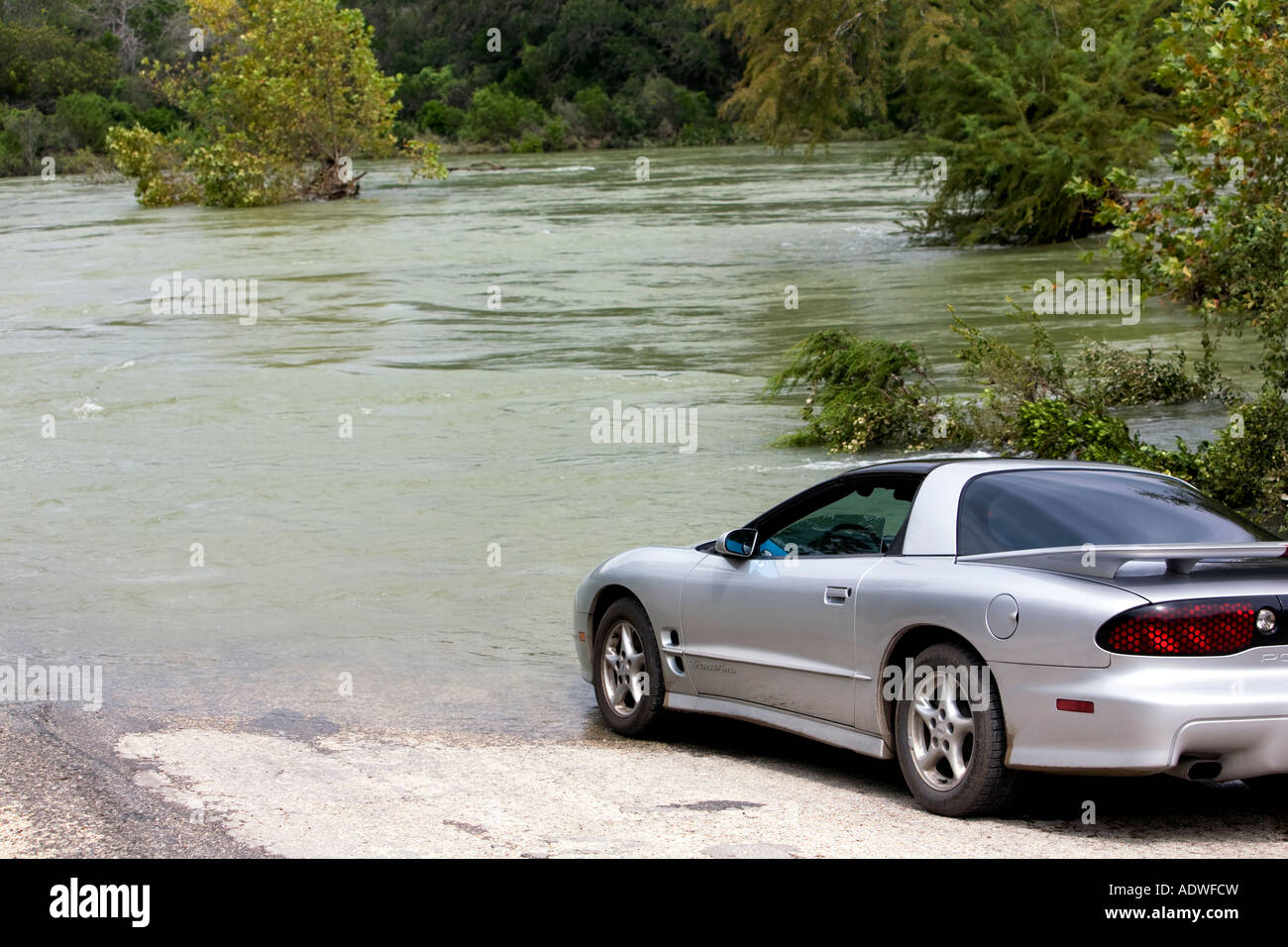 Flood Trans Am no road Texas, Road goes into raging river. Stock Photo