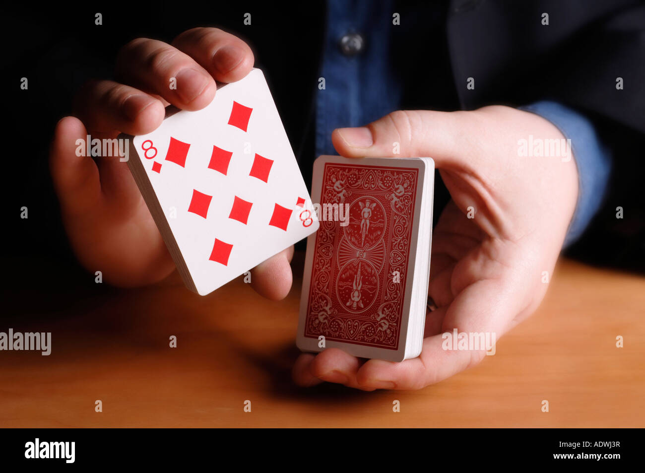 Man cutting deck of cards to eight of diamonds Stock Photo Alamy