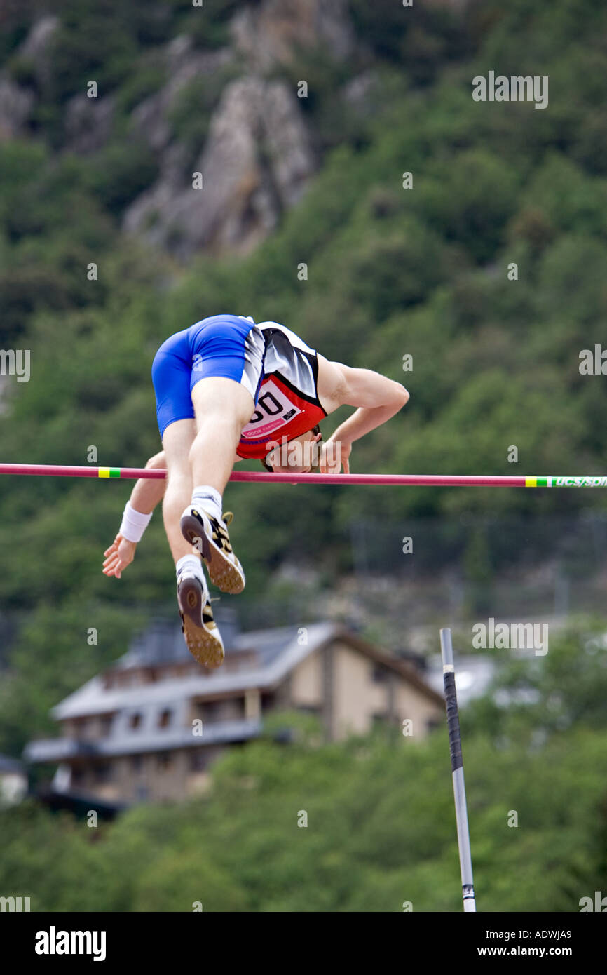Athlete clearing the cross bar in a pole vault competition Stock Photo