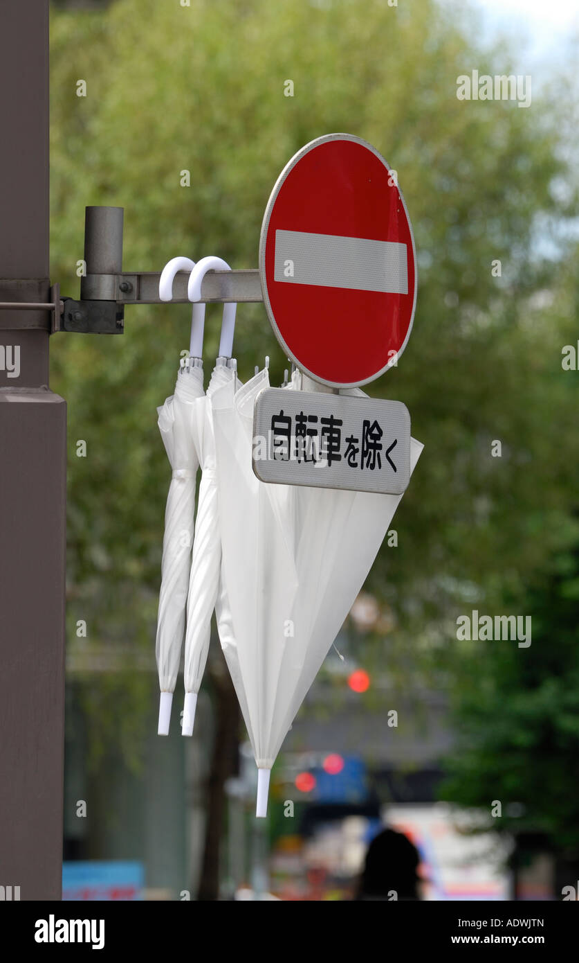 White sunshades hanging on a traffic sign in Ginza, Tokyo JP Stock Photo