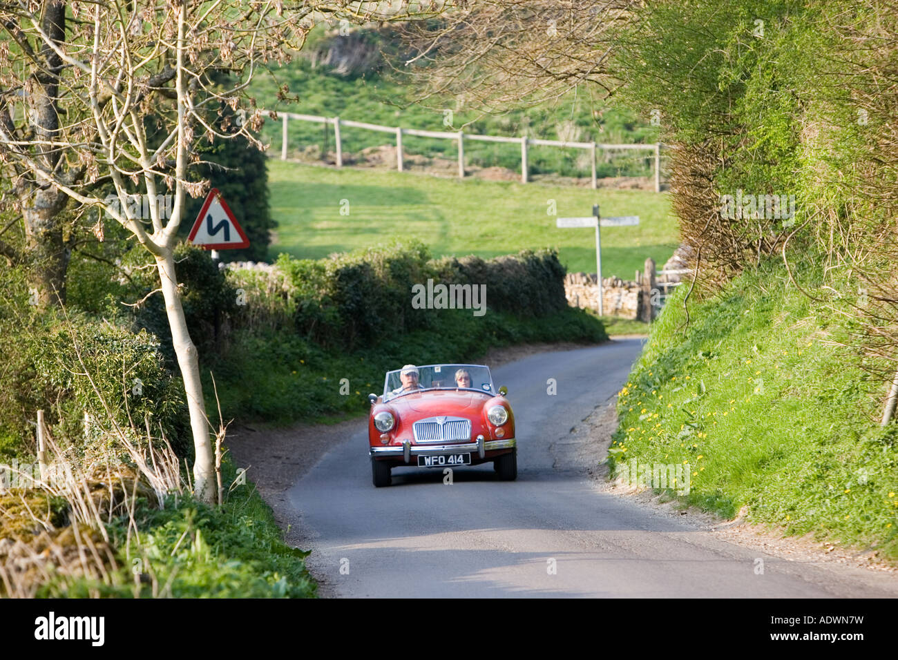 MG sports car convertible travelling on winding country road Swinbrook