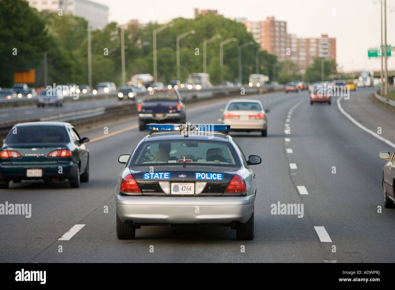 State Police car travelling among volume of traffic on freeway