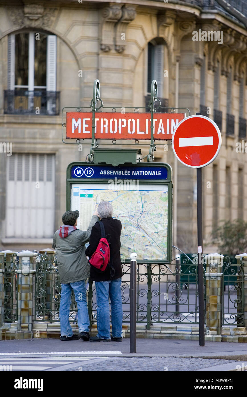 Tourists on foot study Metropolitain subway map for the Paris Metro in Rue du Bac Left Bank Paris France Stock Photo