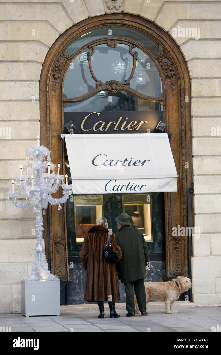 Stylish couple with dog look in Cartier shop window in Place Vendome Central Paris France Stock Photo