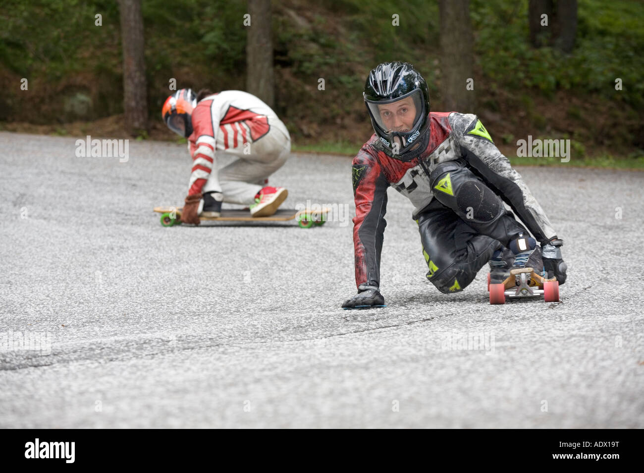 A skater speeding through curve and the other gets uncontrolled slide Stock Photo