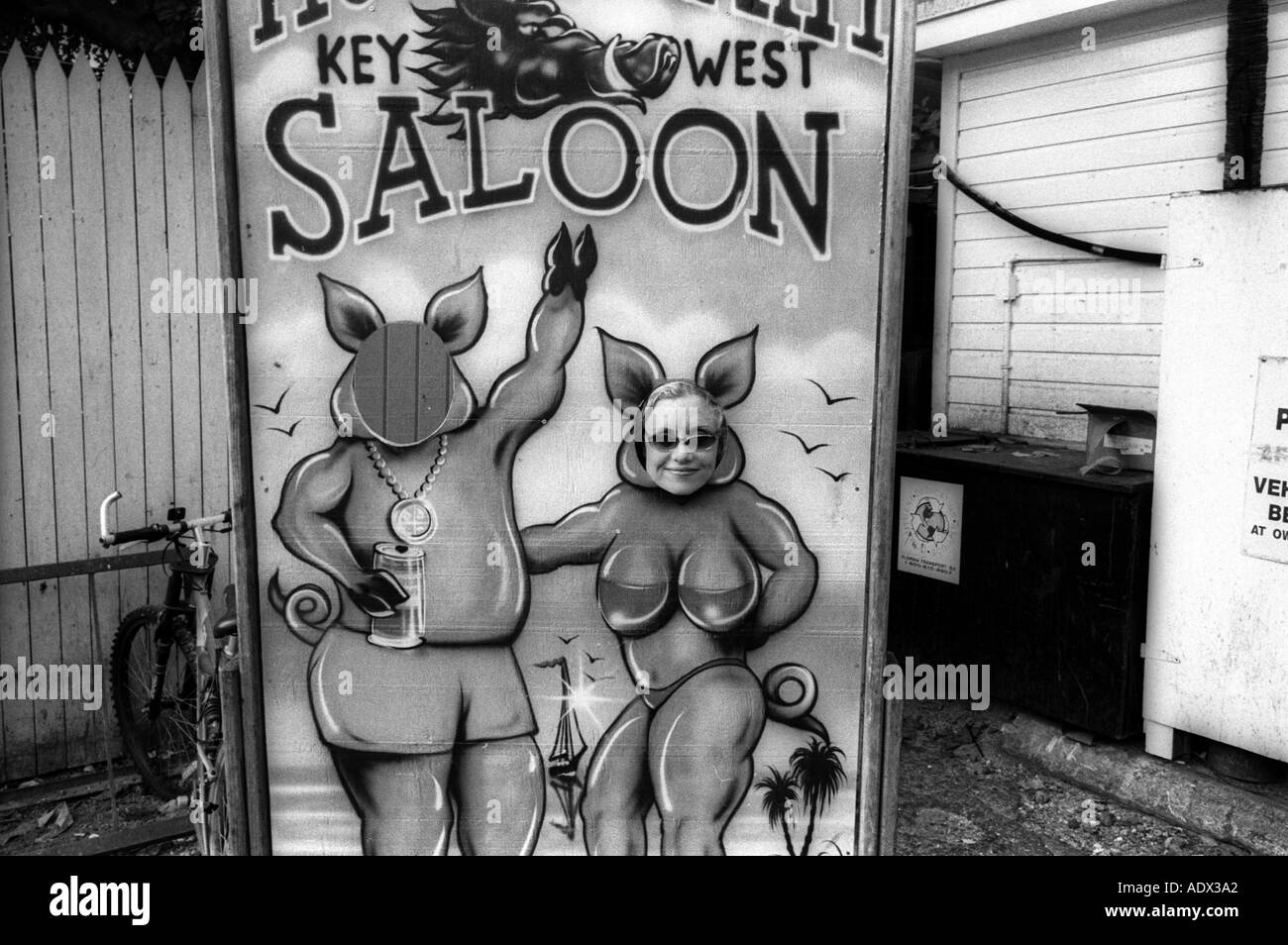 Key West Florida Woman looks through funny sign painting at the Hogs Breath Saloon Stock Photo