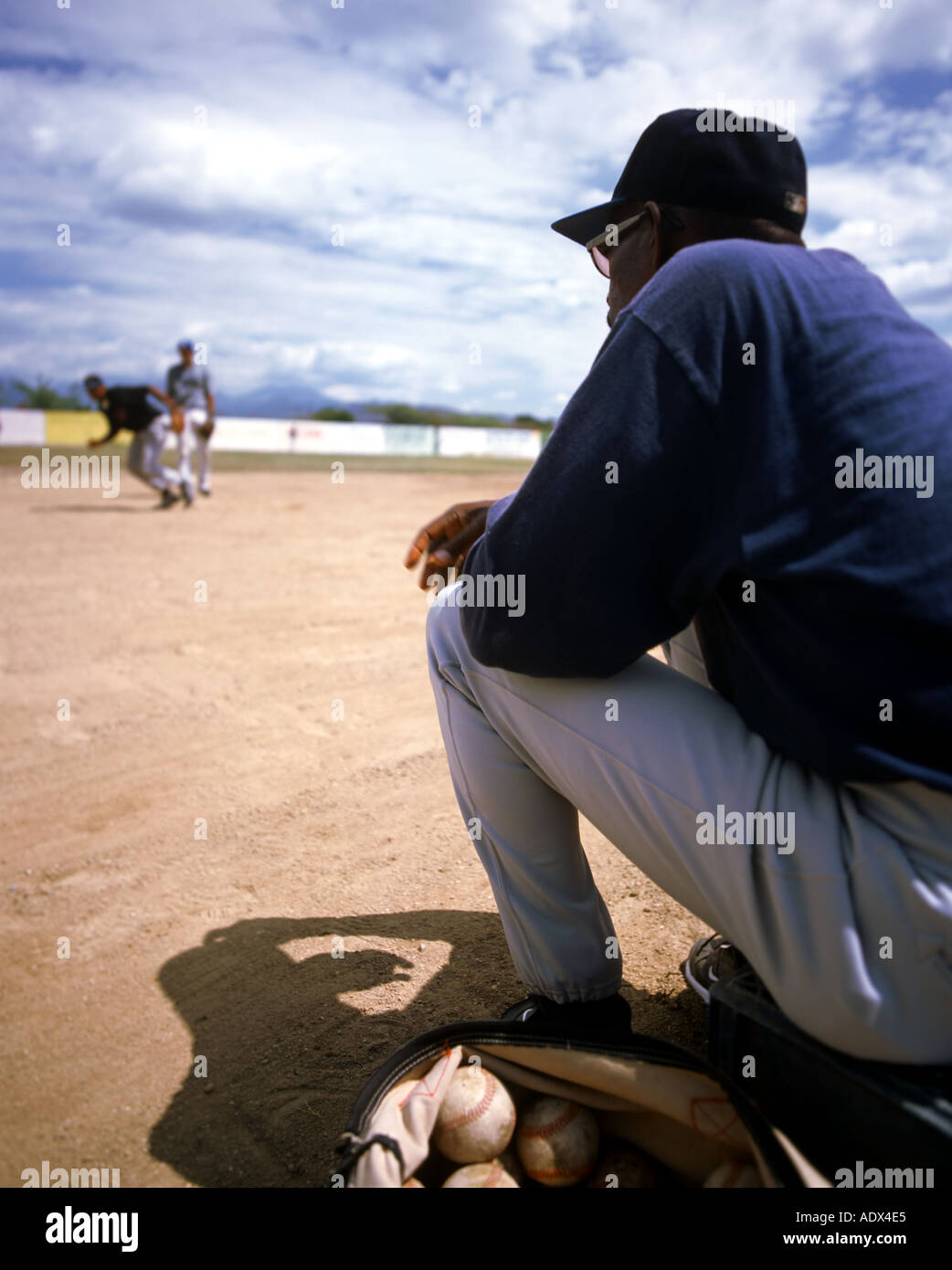 Young boys take fielding practice under the watchfull eye of their baseball coach at a school in Bani Dominican Republic  Stock Photo