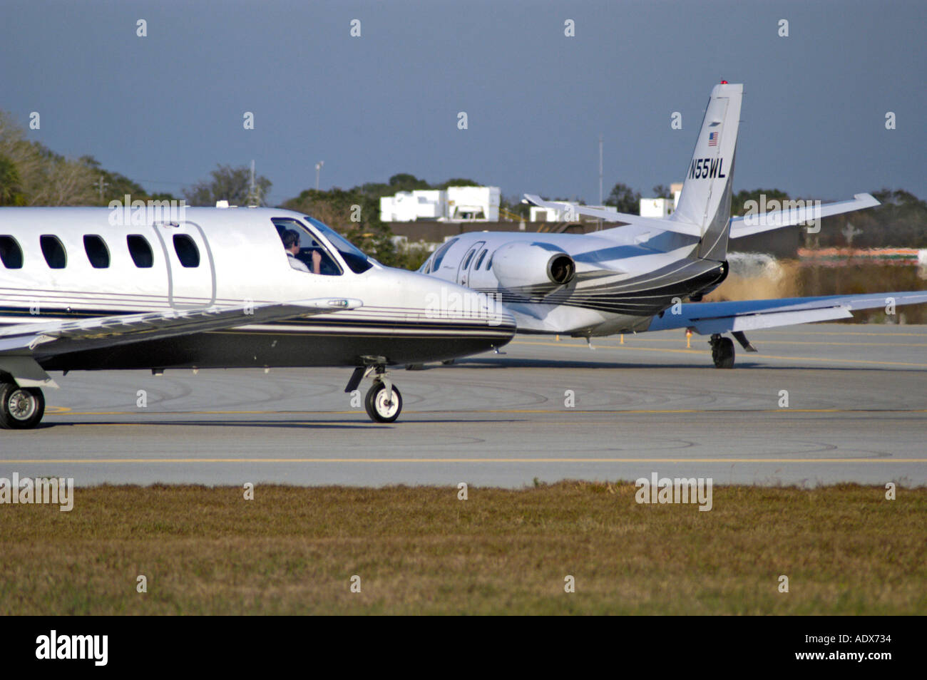 Airplanes following each other to takeoff biz jets cessna citations Stock Photo